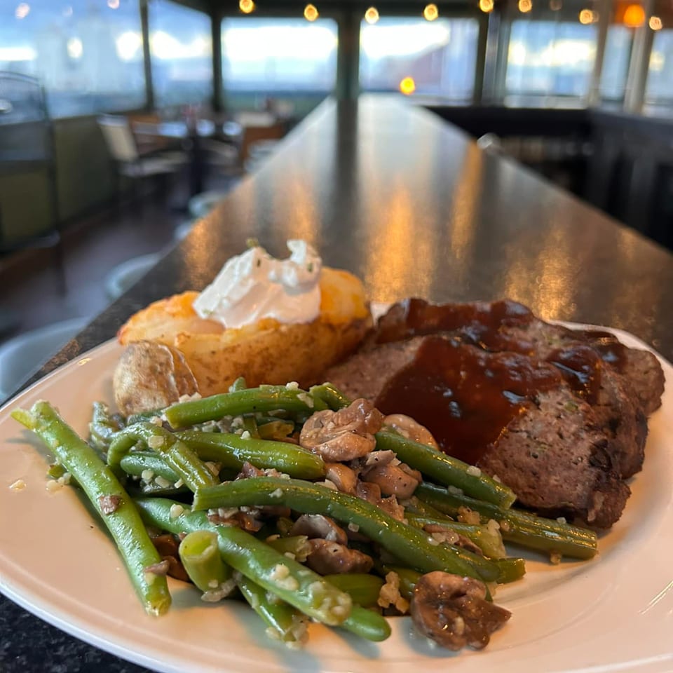 Meatloaf with gravy, green beans, mushrooms, and a baked potato with sour cream at GS Steamers.